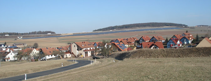 Holzkirchhausen mit Freiflächenanlage im Hintergrund